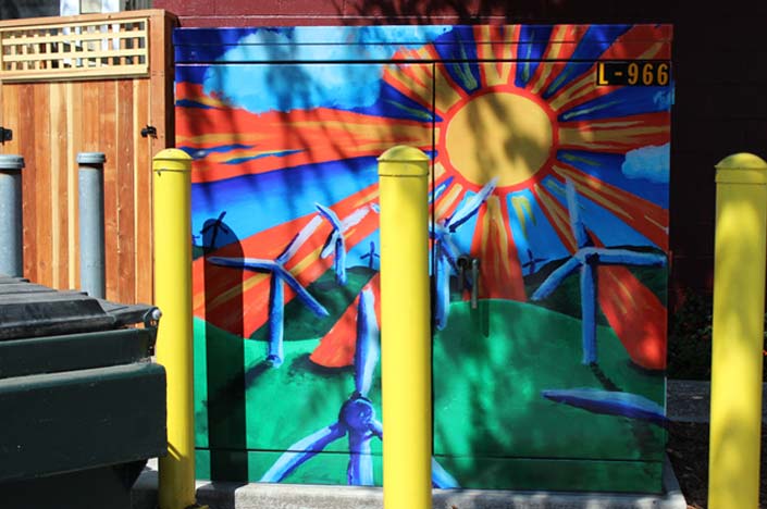 A power box with a sun and wind turbine generators painted on it.