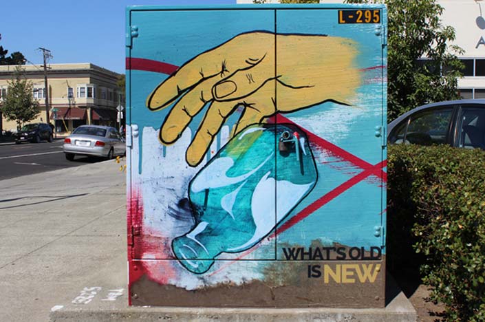 A power box with the painting of a hand dropping a glass bottle on it.